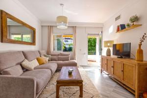 ein Wohnzimmer mit einem Sofa und einem TV in der Unterkunft 2034 Hacienda Nagueles I Marbella Golden Mile in Marbella