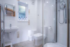 a bathroom with a toilet and a sink and a shower at Three Cliffs Cottage - 2 Bedroom - Parkmill in Parkmill +26 photos