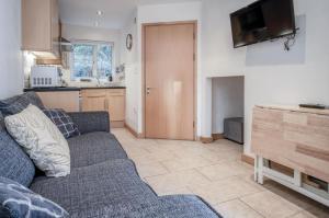 a living room with a couch and a kitchen at Three Cliffs Cottage - 2 Bedroom - Parkmill in Parkmill