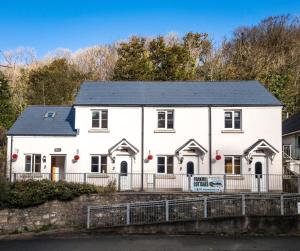 a white house with a black roof at Three Cliffs Cottage - 2 Bedroom - Parkmill in Parkmill