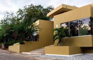 uma casa amarela com escadas em frente em Lagos del Peñon, Casa Arena em Girardot