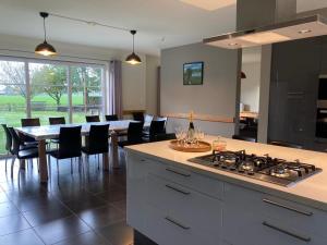 a kitchen and dining room with a table and a stove at De Smokkelaar & Het Schuurtje in Maldegem