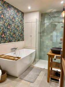 een badkamer met een bad en een glazen douche bij Superbe loft Pigalle / Opéra in Parijs