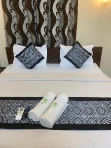 uma cama com duas almofadas e toalhas em Baga Beach Crystal em Baga