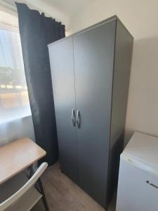 a cabinet in a kitchen with a desk and a refrigerator at Oxborne Rooms UK - Seaton in London