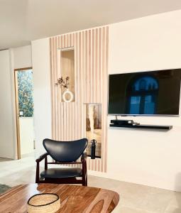 een woonkamer met een stoel en een tv aan de muur bij Superbe loft Pigalle / Opéra in Parijs