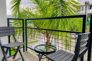 uma varanda com duas cadeiras e uma palmeira em Residencial Bambú Pool Beach 5 mins Near Town em Puerto Vallarta