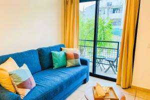 um sofá azul numa sala de estar com uma varanda em Residencial Bambú Pool Beach 5 mins Near Town em Puerto Vallarta