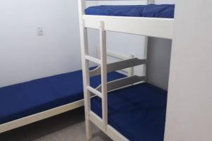 En eller flere senge i et værelse på Casa a 5 minutos a pé da Praia da Enseada!