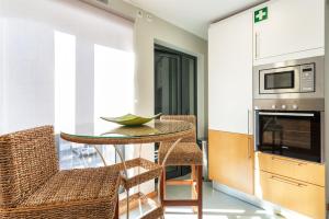 uma cozinha com mesa e cadeiras num quarto em Privilege Apartment Ciboulette with Rooftop Pool, Village Marina - Olhão em Olhão