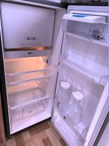 - un réfrigérateur ouvert avec une porte ouverte et des bouteilles de lait dans l'établissement Lola's Loft, à Grecia