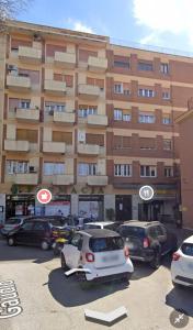 a parking lot with cars parked in front of a building at La Casa di Dany in Rome