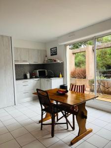 une cuisine avec une table en bois et deux chaises dans l'établissement 4SAP22 Appartement climatisé avec double terrasses, à Collioure