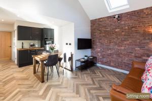 a kitchen and dining room with a table and a brick wall at Station Cottage in North Berwick +10 photos