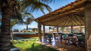un patio con mesas y sillas bajo una sombrilla grande en Playa Paraíso, en Playas