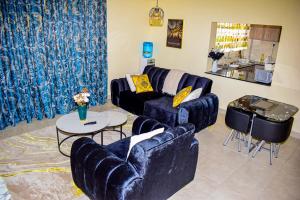 una sala de estar con sofás azules y una mesa. en San Haven, en Kisumu