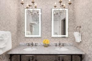 a bathroom with two sinks and two mirrors at Hamilton Turner Inn in Savannah