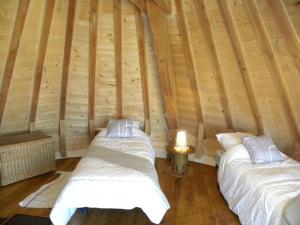 2 camas en una habitación con paredes de madera en Moulin de Salles en Mas-dʼAuvignon