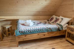 ein Schlafzimmer mit einem Bett in einem Blockhaus in der Unterkunft Agroturystyka "Na Zogrodzie" Alicja Kowalczyk in Harklowa