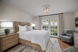 a bedroom with a bed and a chair and a window at Hamilton Turner Inn in Savannah