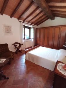 een slaapkamer met een groot wit bed en een stoel bij Antica Riserva in Castiglione del Lago