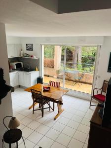 Il comprend un salon avec une table en bois et une cuisine. dans l'établissement 4SAP22 Appartement climatisé avec double terrasses, à Collioure