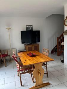 uma mesa de madeira com cadeiras e uma televisão num quarto em 4SAP22 Appartement climatisé avec double terrasses em Collioure