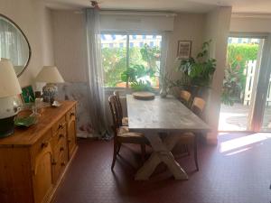 jadalnia ze stołem i krzesłami oraz oknem w obiekcie Appartement proche plage w Biarritz
