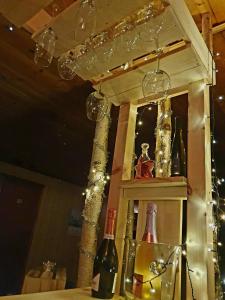 a shelf with wine bottles and lights on it at Schnieders1German forest B&B in Harmånger