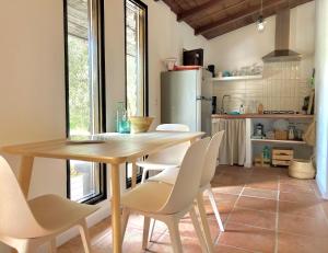 uma cozinha com uma mesa e cadeiras e um frigorífico em Cabaña La Pura Vida Yunquera em Yunquera