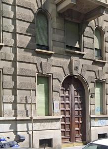 a building with a brown door and three windows at Cà Bèla - Certosa in Milan