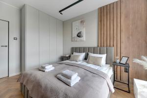 a bedroom with a large bed with towels on it at Flatbook - City Center Apartments Granaria in Gdańsk