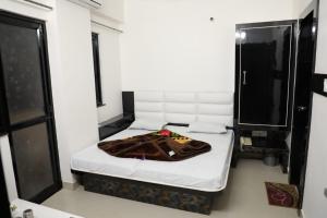 a small room with a bed with a blanket on it at Hotel Sahil 4 Min Distance from Dargah in Ajmer