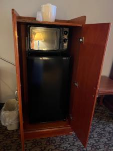 a small microwave sitting on top of a refrigerator at Hotel Xola in Moreno Valley