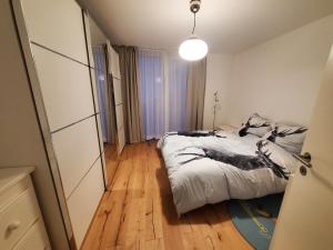 Schlafzimmer mit einem Bett und Holzboden in der Unterkunft Panorama * in Obstalden