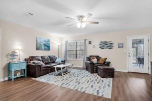 a living room with two couches and a ceiling fan at Gulf Breeze - Canal front, Near Beach & Downtwn 3BR-2BT in Gulf Breeze