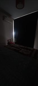 ciemny pokój z krzesłem i jasnym w obiekcie Departamento céntrico y silencioso con patio privado w mieście Mendoza