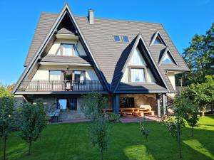 una vista exterior de una casa con techo de gambrel en POKOJE "CICHA" ZAKOPANE en Zakopane