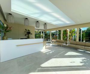 a lobby with a white counter and some windows at Bungalows Cordial Sandy Golf in Maspalomas