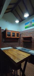 cocina con mesa de madera y pared de ladrillo en Lala Guest House, en Bubunan