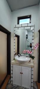 een badkamer met een wastafel en een grote spiegel bij Lala Guest House in Bubunan