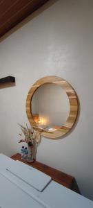 een ronde spiegel aan een muur met een tafel bij Lala Guest House in Bubunan