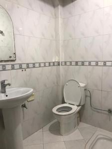 een witte badkamer met een toilet en een wastafel bij Blue Beach Apartments in Taghazout