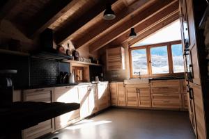 una cocina con armarios de madera y una gran ventana en Espectacular Chalet de Montaña Pirineos, Burg, en Burg