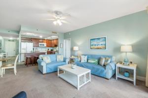 een woonkamer met een blauwe bank en een tafel bij Laketown Wharf #422 by Nautical Properties in Panama City Beach