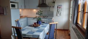 Gite 3 Frontières في Hagenthal-le-Bas: مطبخ صغير مع طاولة مع وعاء من الفواكه عليها