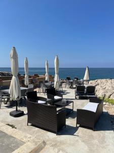 a group of tables and chairs with umbrellas on the beach at Golden Stone Beach 