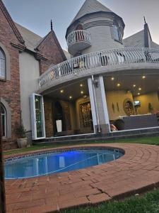 a house with a swimming pool in front of a house at Castle Home in Centurion