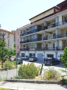 an apartment building with cars parked in a parking lot at Le Giarette in Cefalù