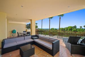 d'une terrasse avec un canapé et des chaises sur un balcon. dans l'établissement Sierra Blanca, à Marbella